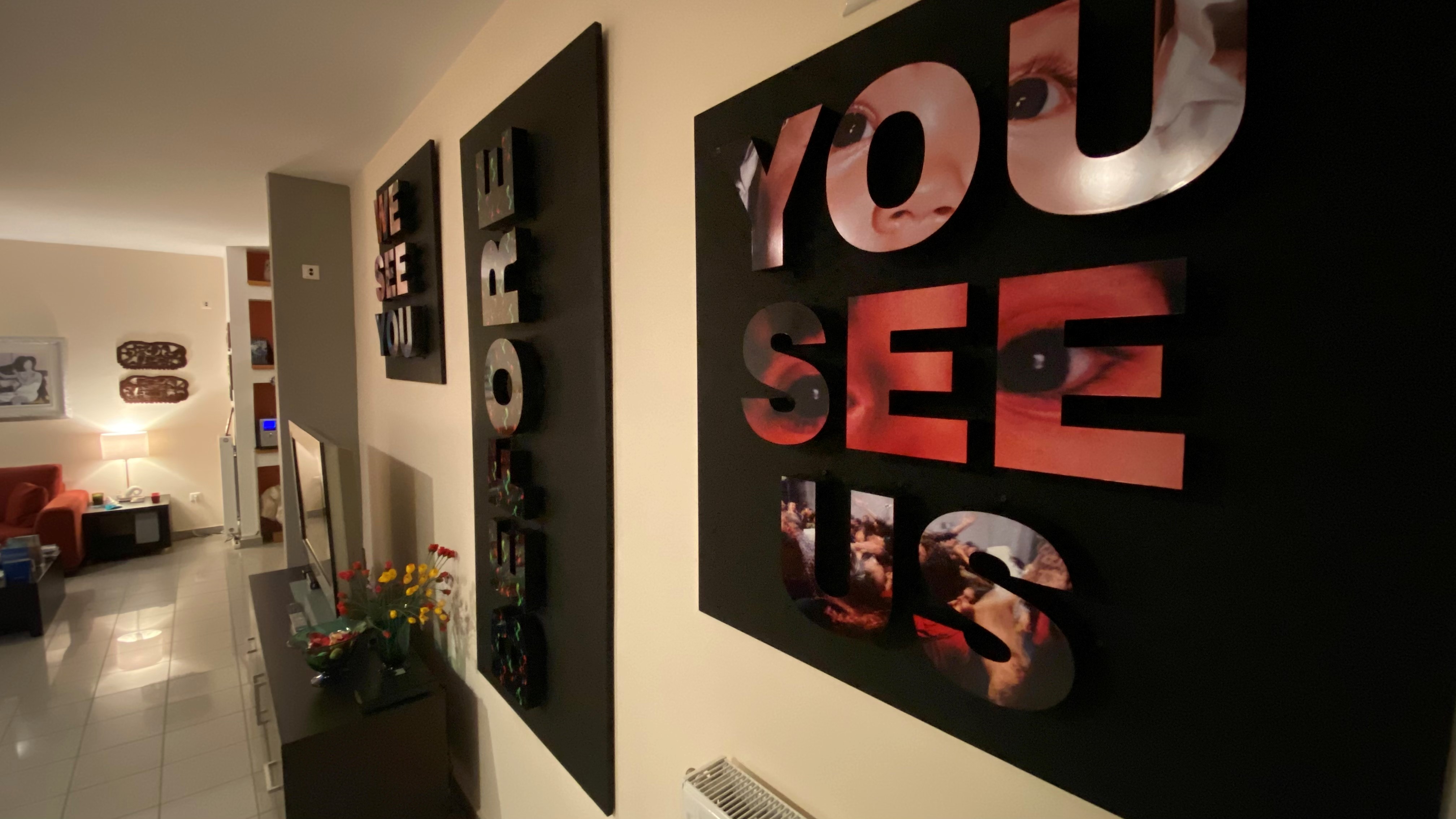 Ο τρίπτυχος πίνακας "We See You Before You See Us" της εικαστικού Σίσσυς Μουριάδου στολίζει το σαλόνι.